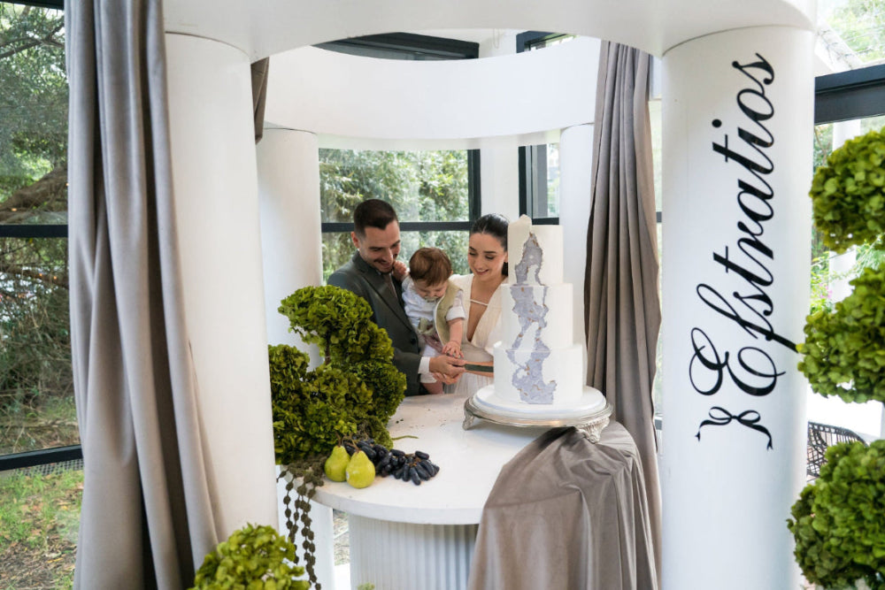 Family with a child in a photo booth with decorative elements and 'Estratios' branding.