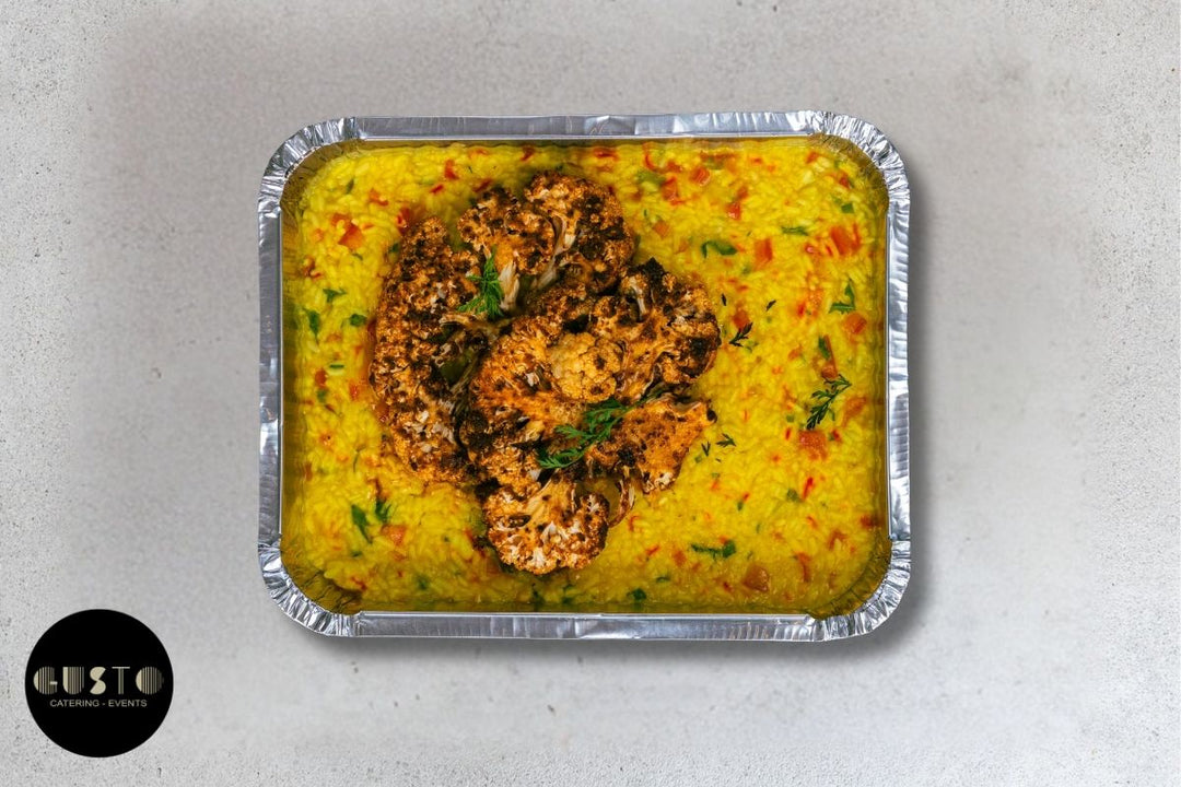 Tray of food with a yellow sauce and a brownish topping on a light gray background, branded 'Gusto'.
